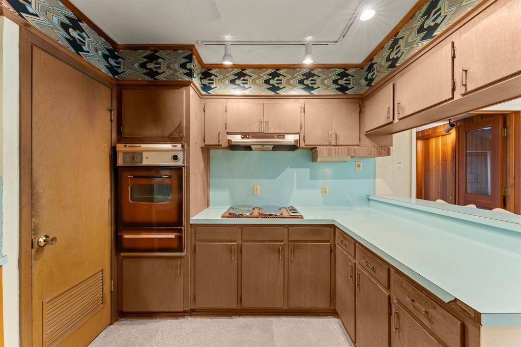 Kitchen sits between dining and vaulted den, and could easily be opened up for additional space.