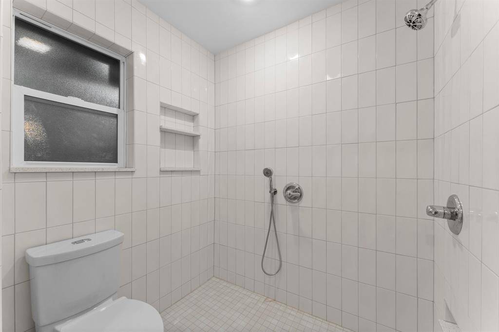 Wet room with separate shower and shower wand, shampoo nook and shaving ledge.