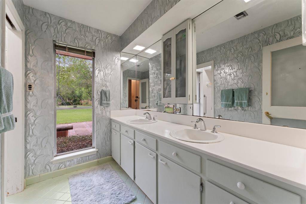 Extra bath with double sinks and view of back yard.