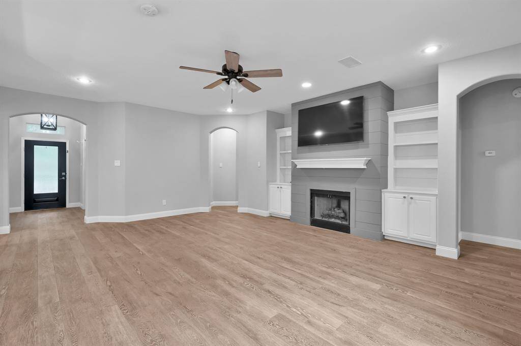 The shiplap fireplace, framed by matching built-in shelving, adds both character and function to the living room.