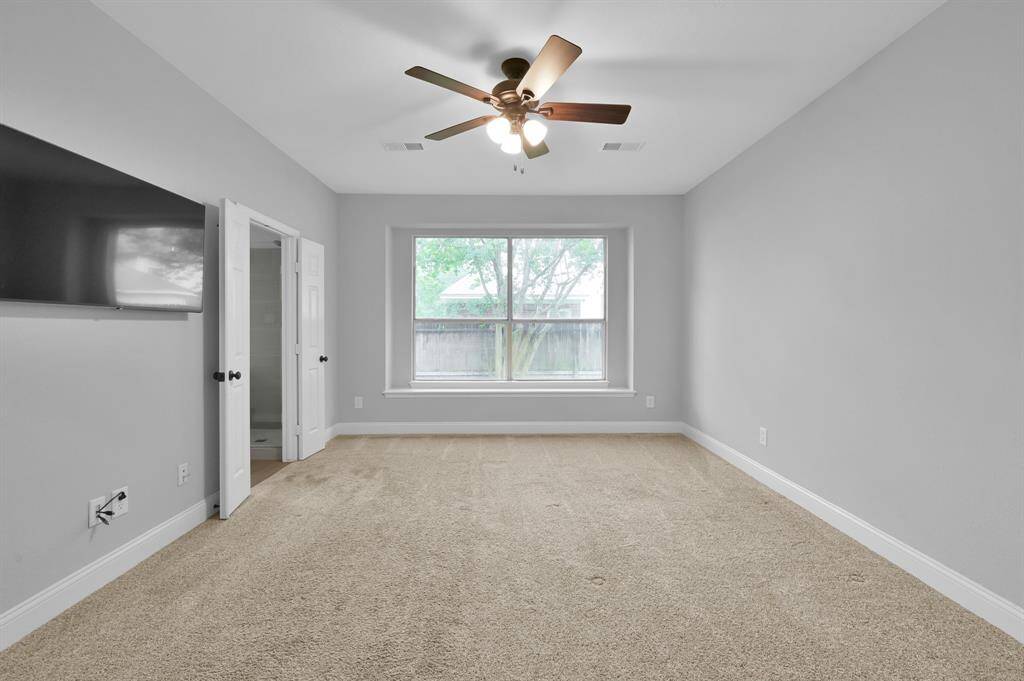 The spacious primary bedroom comfortably fits a king-sized bed and includes a charming window nook.