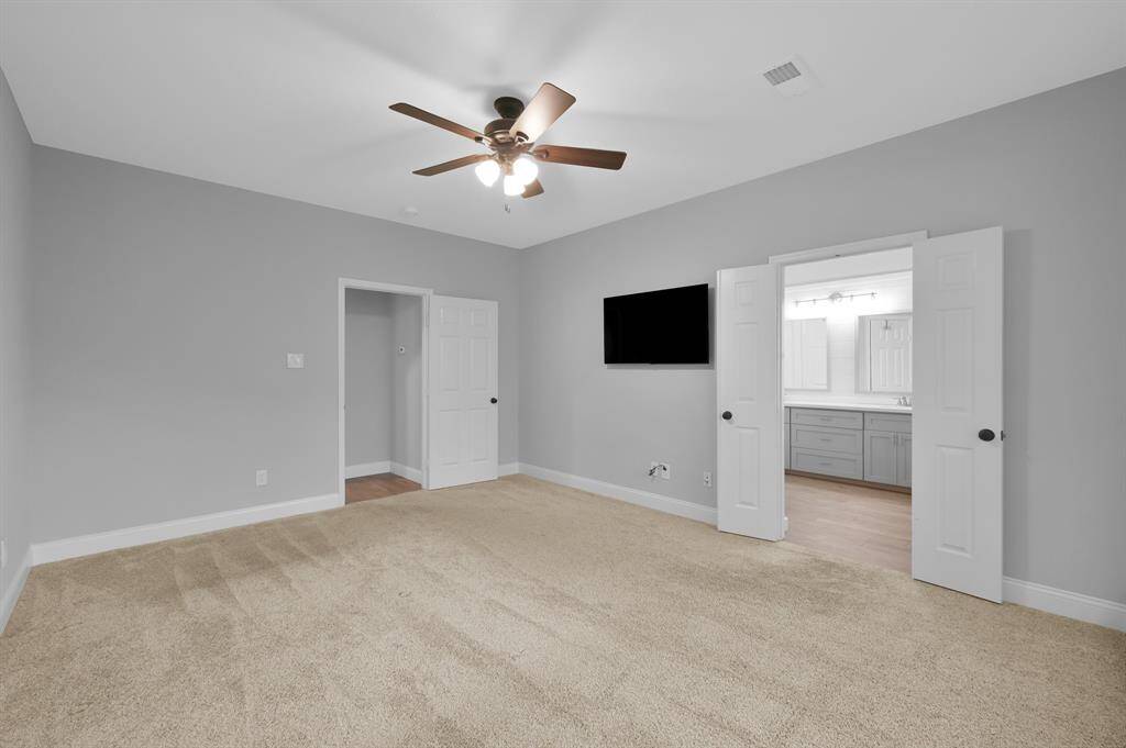 Another angle of the primary bedroom with an updated ceiling fan.