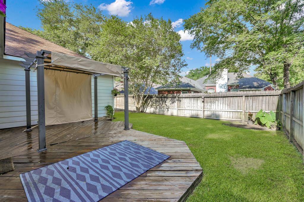 Enjoy outdoor living on the expansive wooden deck, complete with a sunshade and space for dining, grilling, and relaxing.