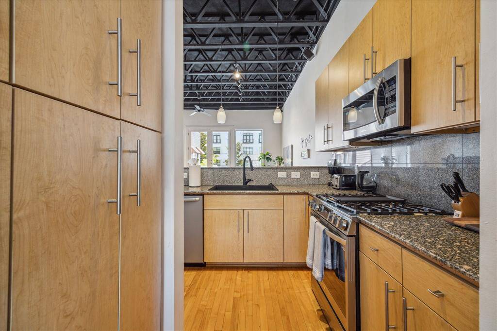 The kitchen is equipped with stainless steel appliances and a refrigerator.