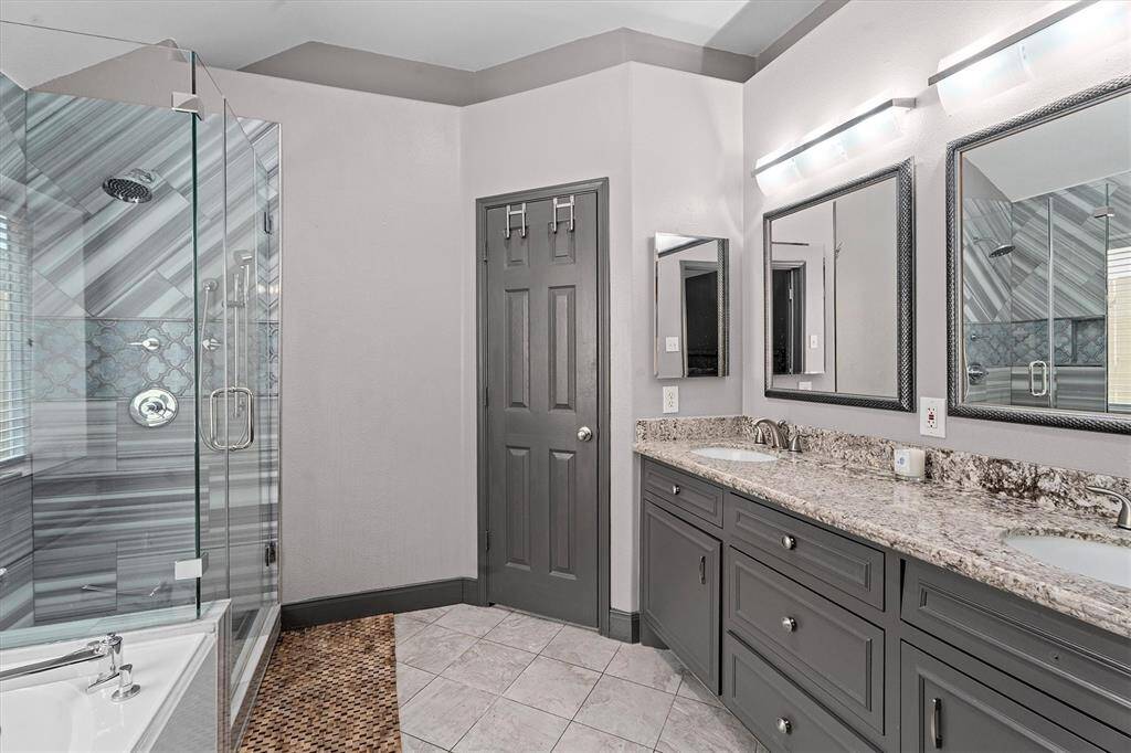 primary en suite bathroom with custom tile shower, soaking tub & double vanity
