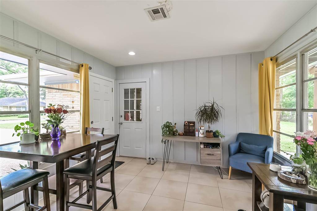 Natural light floods this room from the walls of windows. It boasts ceramic tile floor and pleasing paint color and this wall of windows overlooks the side patio. Note: Solid door leads to side patio and driveway, while the door with glass panels leads to the garage