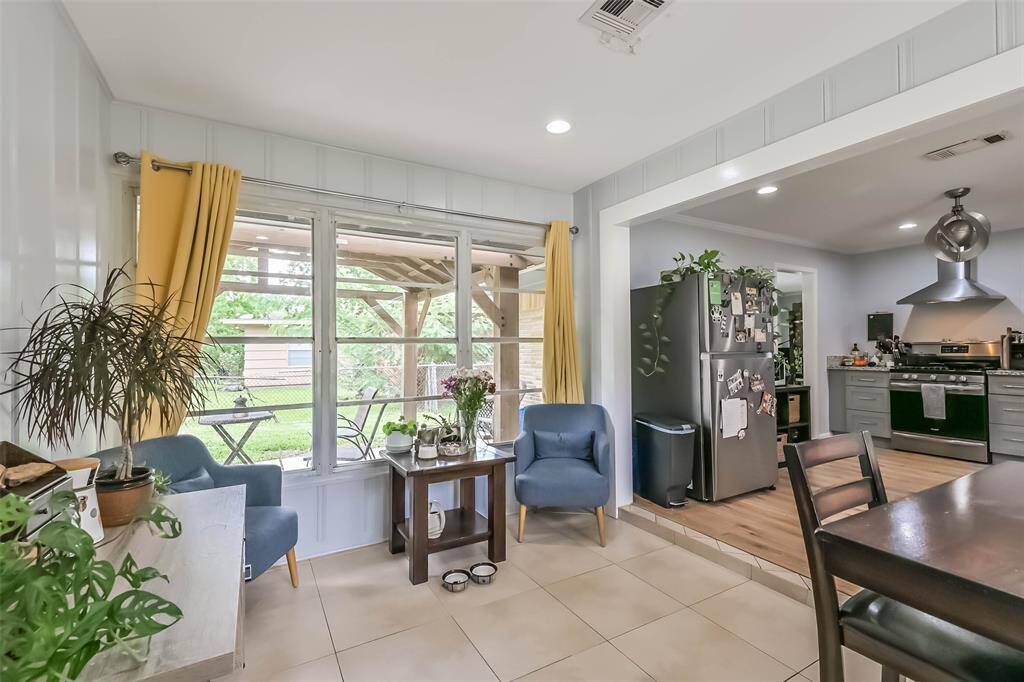 So many possibilities for this room: use the space as a breakfast room, sitting room, sunroom—get creative. This wall of windows overlooks the backyard pavilion. Notice the recessed lighting and view across the kitchen