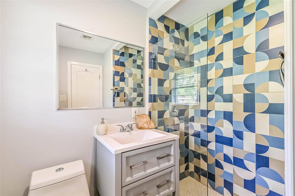 Ensuite bathroom within the Primary bedroom boasts vinyl plank floor, stylish upgraded shower, designer vanity and framed mounted mirror