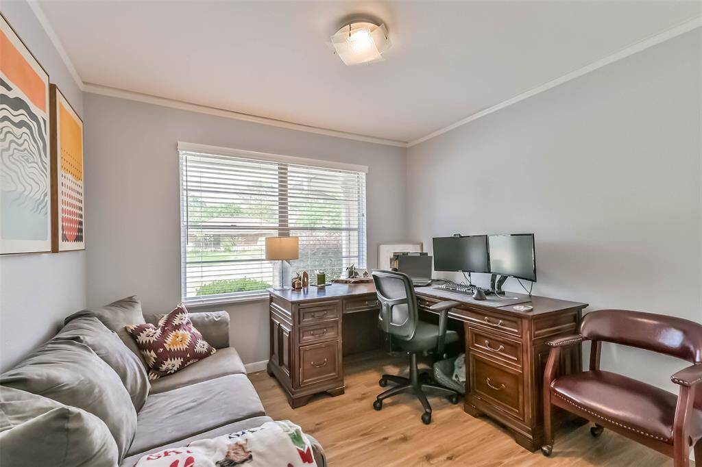 One of the secondary bedrooms which boasts vinyl plank flooring, pleasing paint color, decorative base & crown molding and window that overlooks the front yard