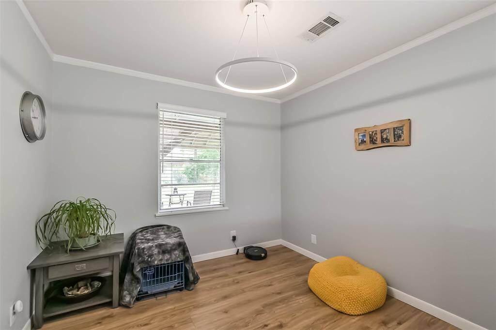 Dining room opens to living room and boasts vinyl plank floor, stylish lighting and windows overlooking backyard