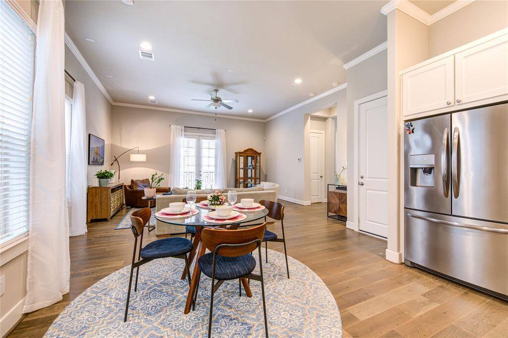 Elegant lighting and French Oak hardwood floors tie the room seamlessly into the home's sophisticated design, while the open layout keeps it connected to the kitchen and living areas for effortless flow.