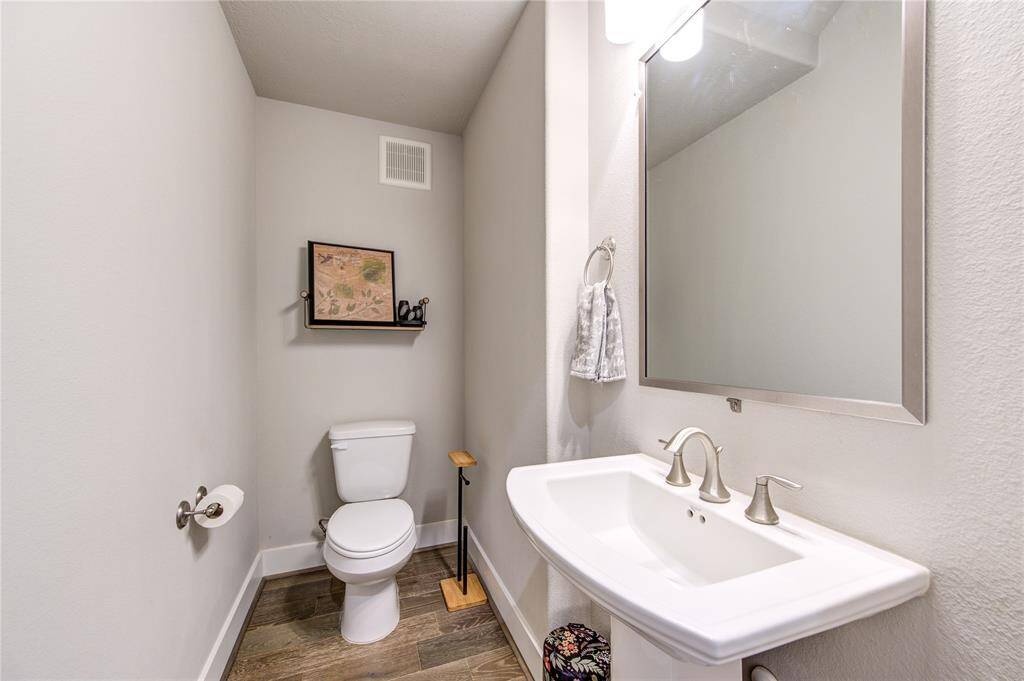 Elegant powder bath conveniently located on the first floor for guests, featuring French Oak floors and a pedastal sink.