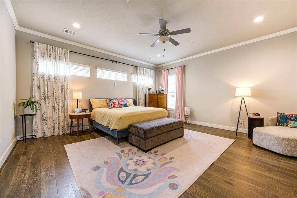 Serene primary suite  on the second floor with coffered ceiling detail, abundant natural light, and French Oak flooring for a sophisticated, serene retreat.