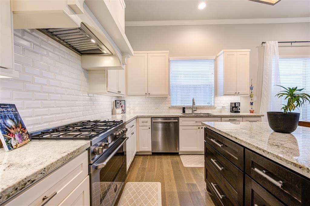 Close-up view of the expansive island with Granite countertops, designer lighting, and generous seating for casual dining.