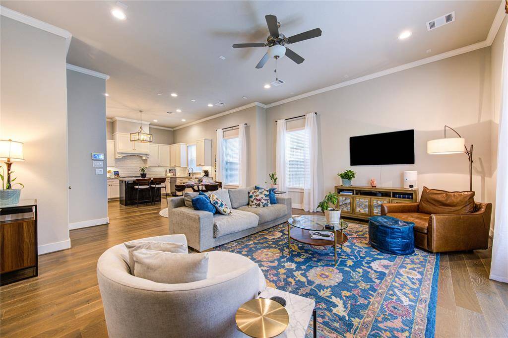 This bright and inviting living room is the heart of the home, featuring soaring 11' ceilings, French Oak hardwood floors, and an abundance of natural light from oversized Low-E windows that frame the room.
