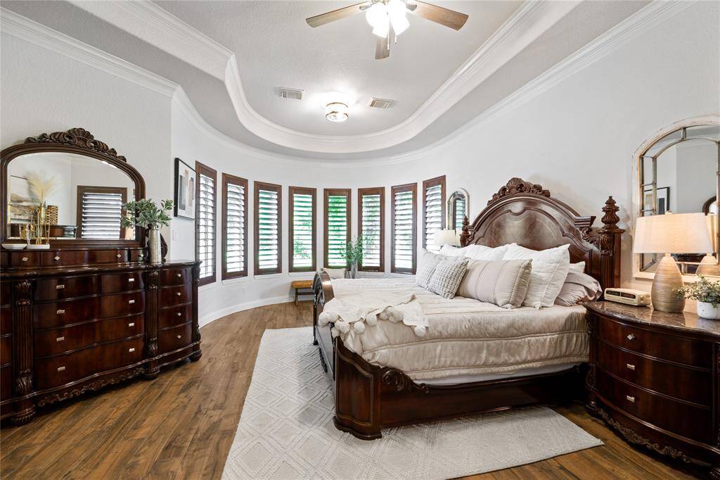 This primary bedroom offers you your sanctuary after a long day of work! Handsome and intricate crown molding, wooden window shutters, and high ceilings really help set the mood of peace and rest!