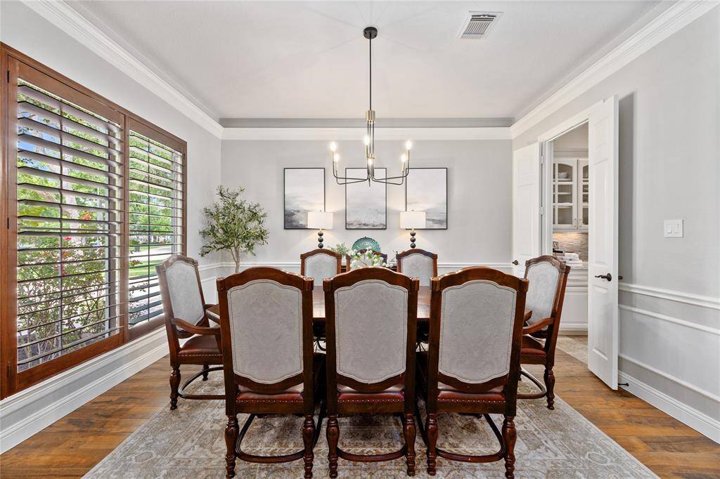 Tons of natural lighting and beautiful Crown Molding in this elegant formal dining area! Notice the updated light fixture, handsome window shutters, and intricate wall molding.