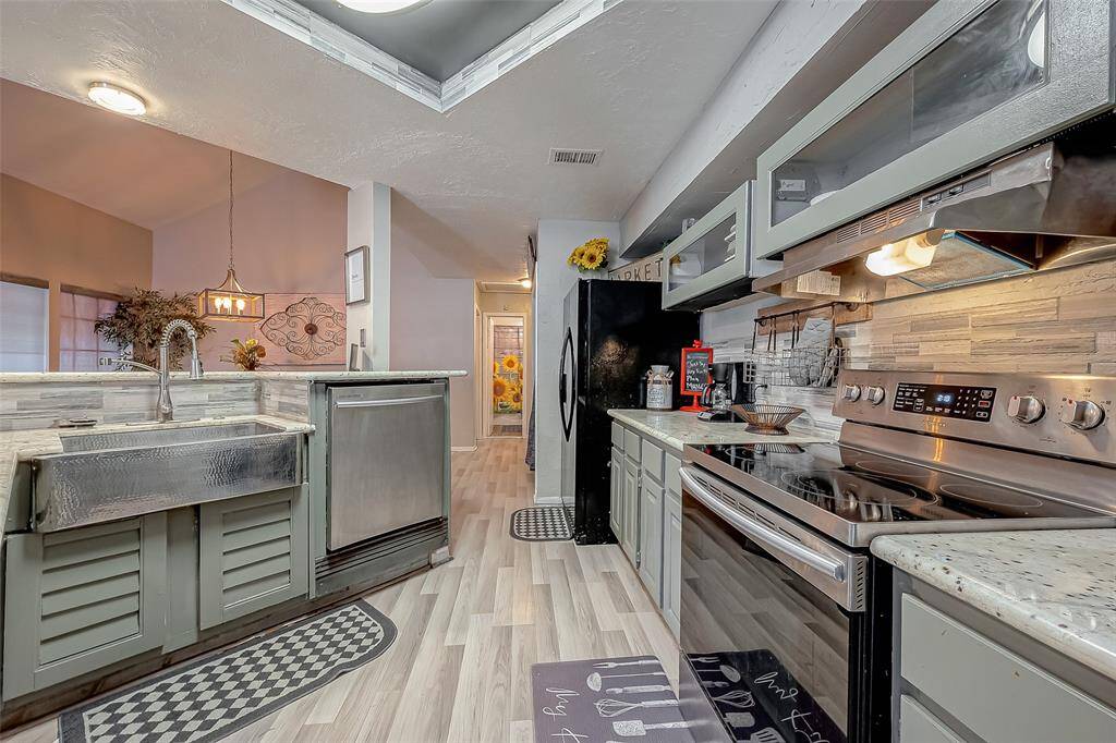 Free flow kitchen with stainless steel appliances.