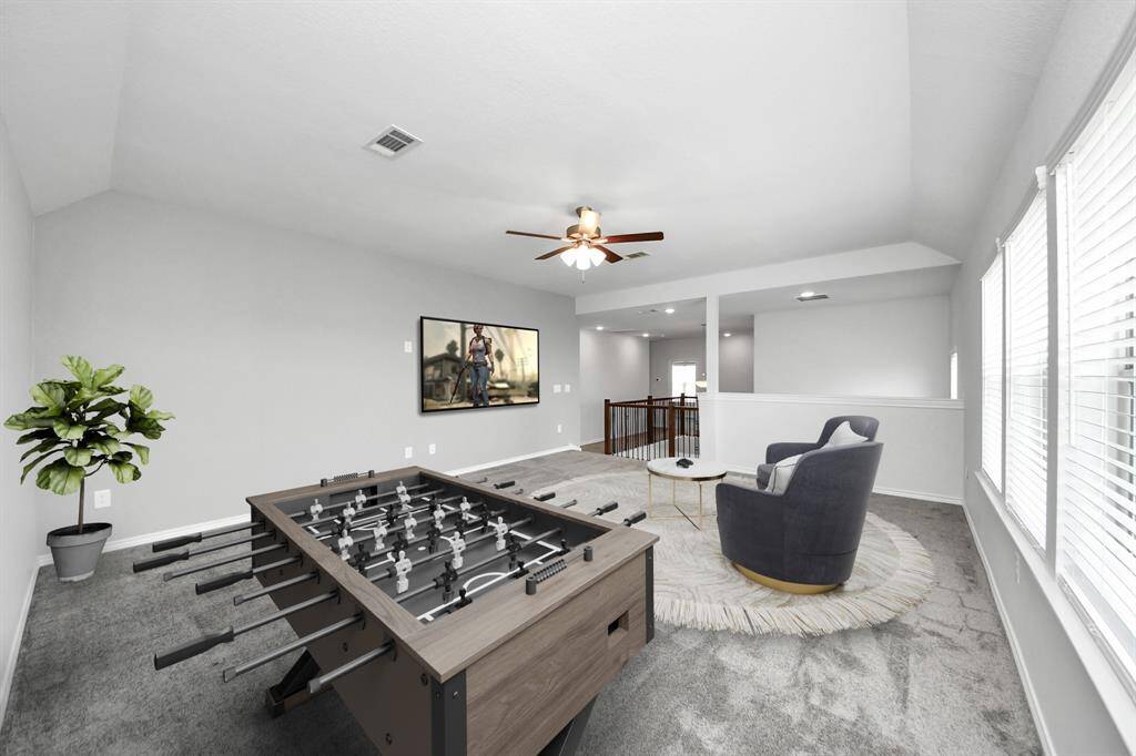 Spacious upstairs game room or flex space with tray ceiling, recessed lighting, and abundant natural light.