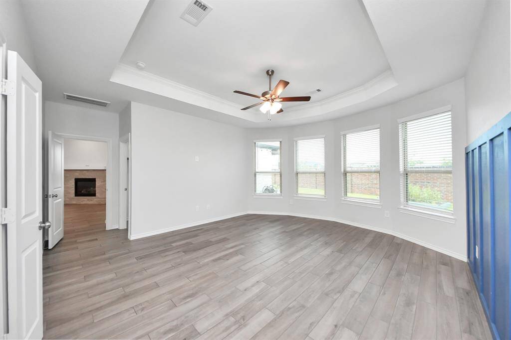 Stylish bedroom with vaulted ceiling, neutral carpet, and a bold wood accent wall.