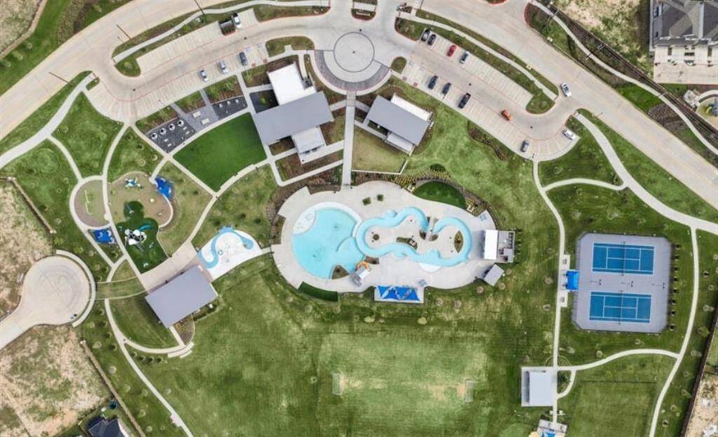 Aerial view of world-class community amenities including pools, splash pad, tennis courts, and green spaces.