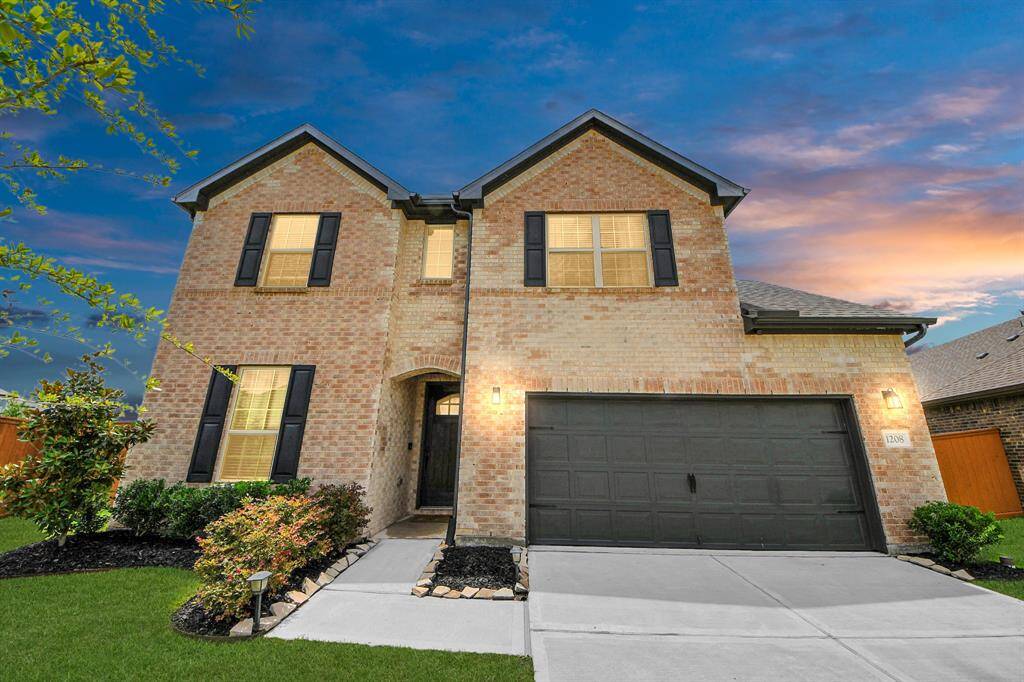 Inviting curb appeal with classic brick façade, dark shutters, and a covered entryway.