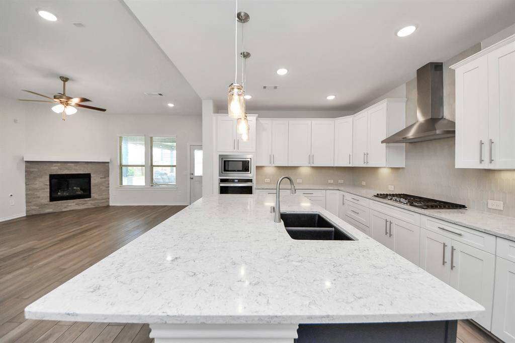 Seamless flow between kitchen and living areas, enhanced by large windows and high ceilings.