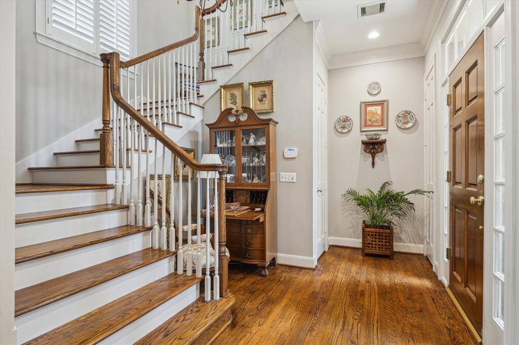 Formal entry with stairwell to 2nd floor with wood treads, designer lighting and coat closets.