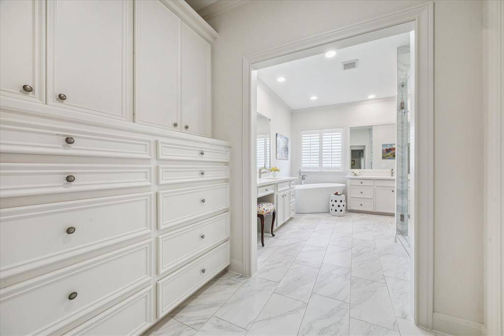 Abundant built-in storage leads into the beautifully updated primary bathroom.