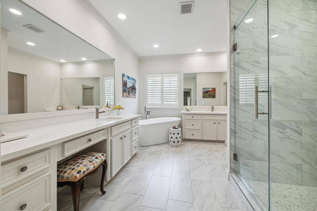 Luxurious, updated primary bath with double sinks, vanity knee area, quartz countertops.