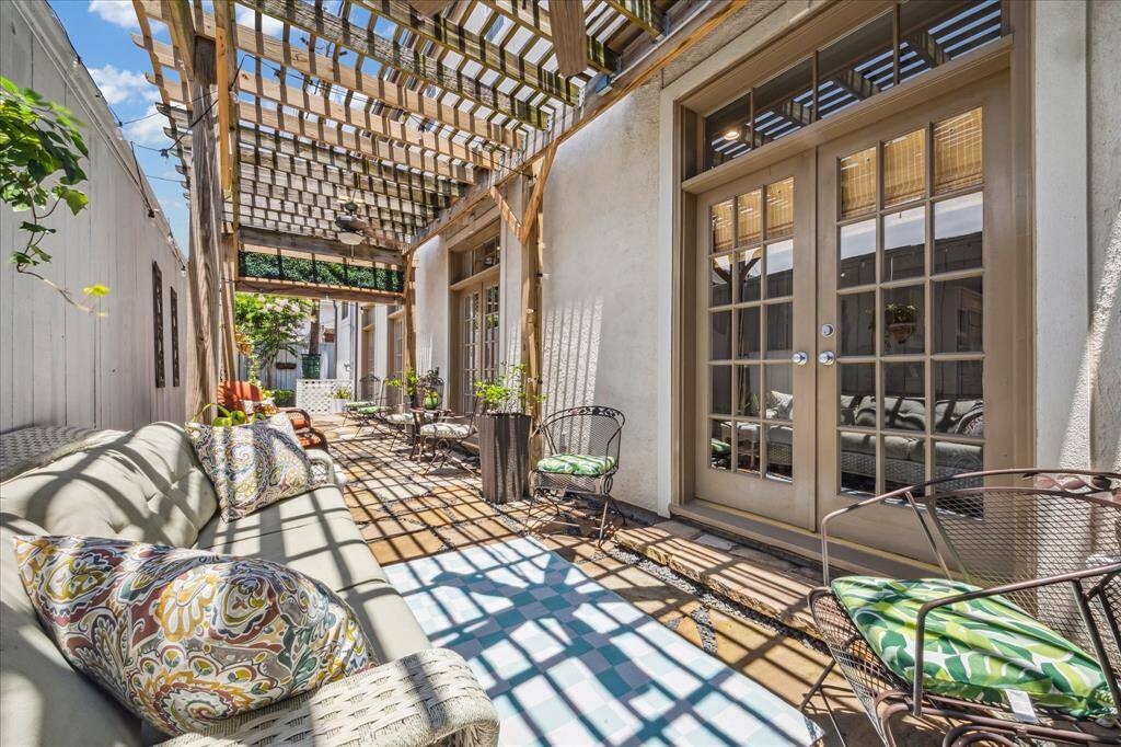 Flagstone patio with pergola, ceiling fans and cafe lights, ideal for outdoor living.