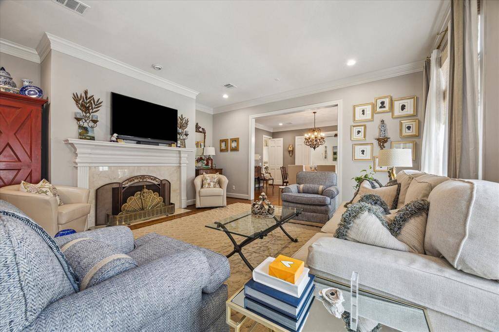The spacious living room features a gaslog fireplace, recessed lighting, double crown molding, and cased opening to the dining room.