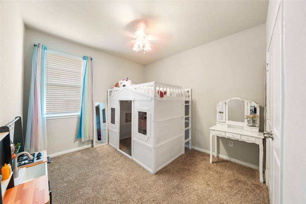 Spacious bedroom featuring ample natural light from the window with curtains.  Plenty of room for large furniture.