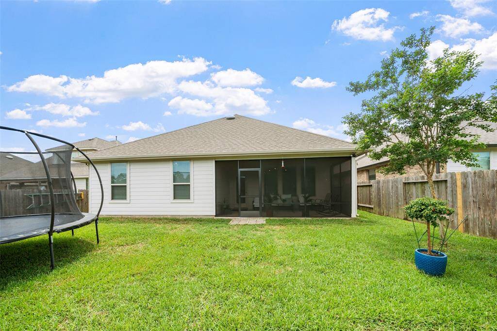 This backyard features a well-maintained lawn, a screened patio for relaxing and a wooden privacy fence. Perfect for family activities and entertainment.  Room for a pool.