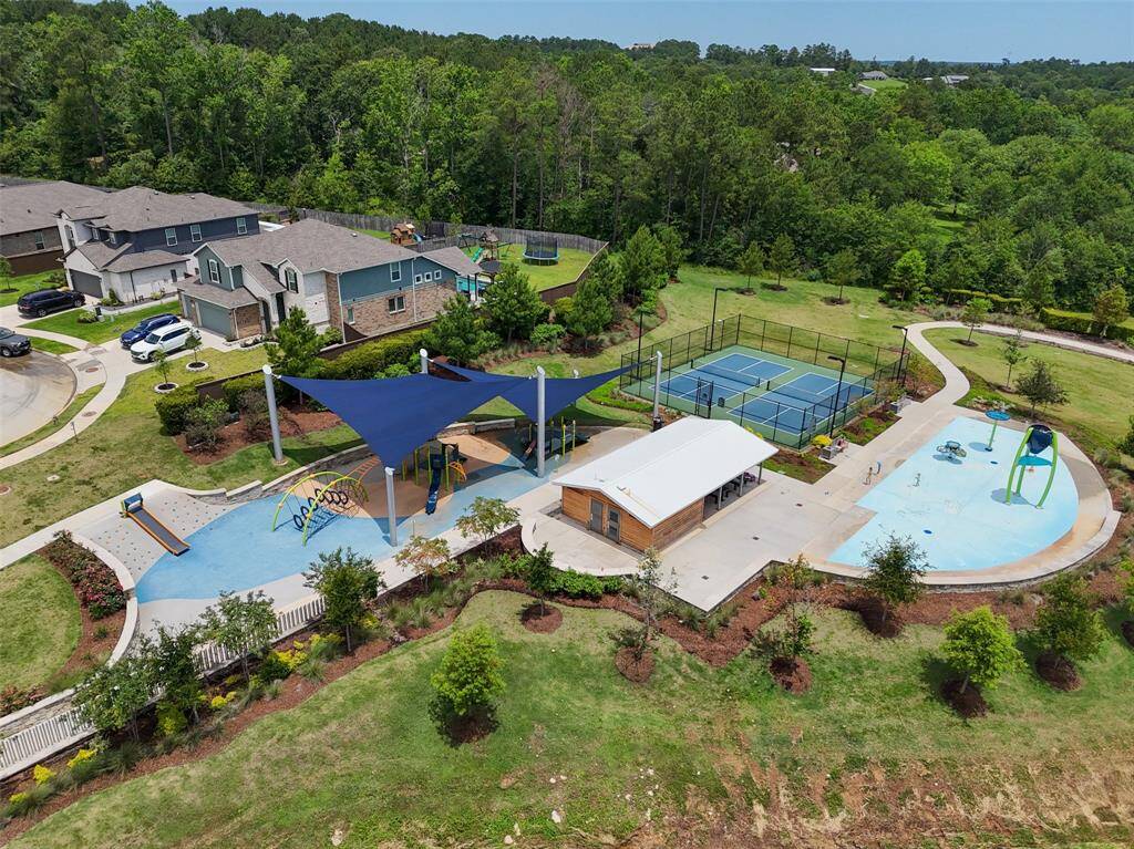 Just a short walk to the vibrant community area featuring a shaded playground, courts, and a splash pad, all surrounded by lush greenery. Perfect for those seeking an active, outdoor lifestyle.