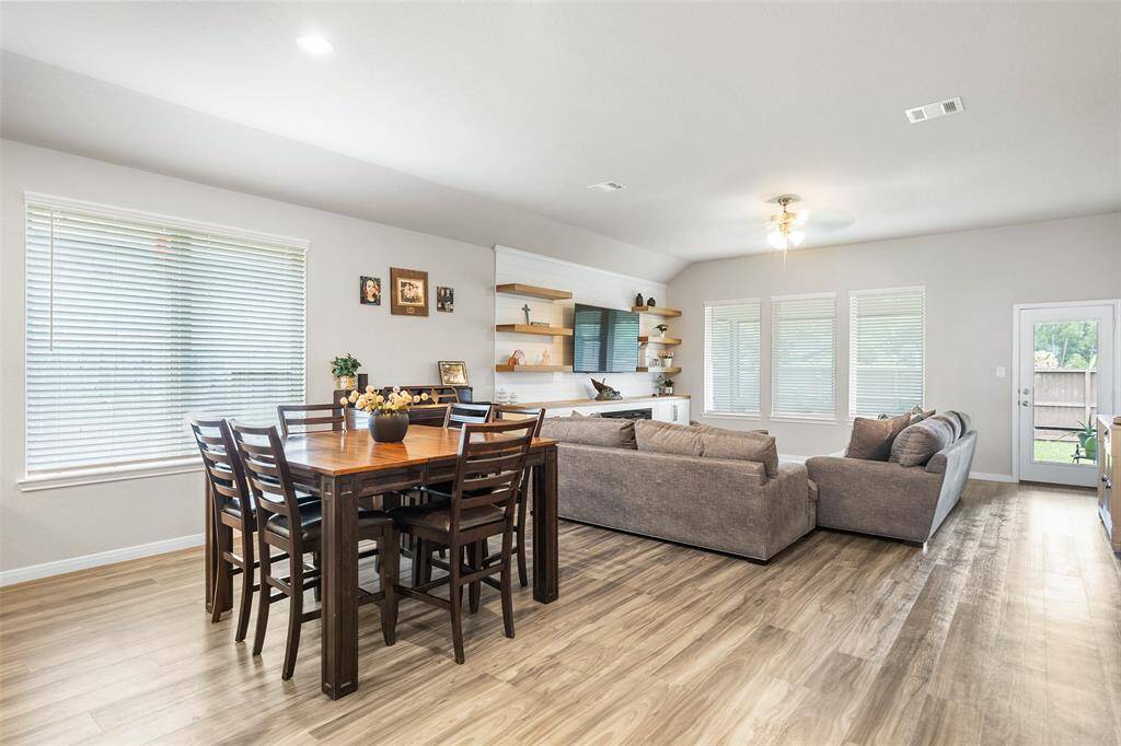This photo showcases a bright, open-concept living and dining area with large windows providing natural light.