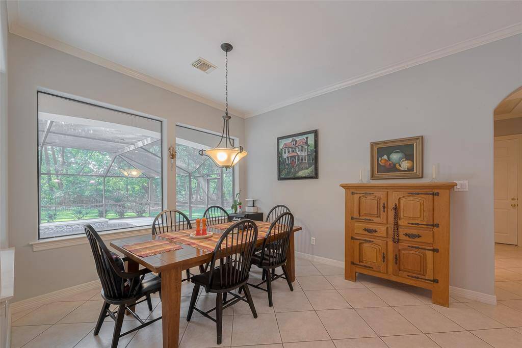 The breakfast room is generously sized and provides beautiful views overlooking the enclosed pool and serene wooded backyard.
