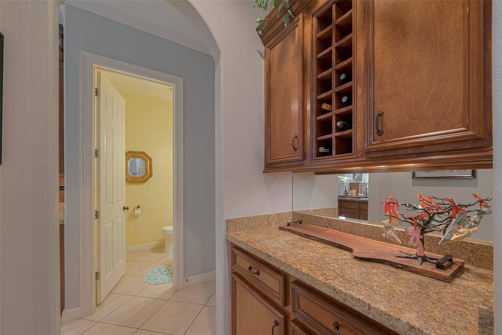 This beautifully designed butler’s pantry offers a perfect staging area, featuring additional granite countertops, extra cabinetry, wine storage, and under-cabinet lighting. A subtle yet elegant custom detail: all the interior walls have rounded corners.