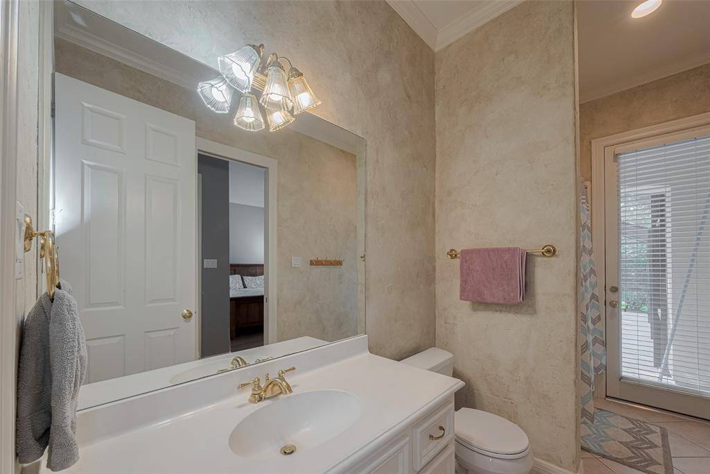 The full bath connected to the downstairs guest bedroom also offers direct access to the backyard and pool—ideal for guests wanting a private space to change or rinse off after a swim.