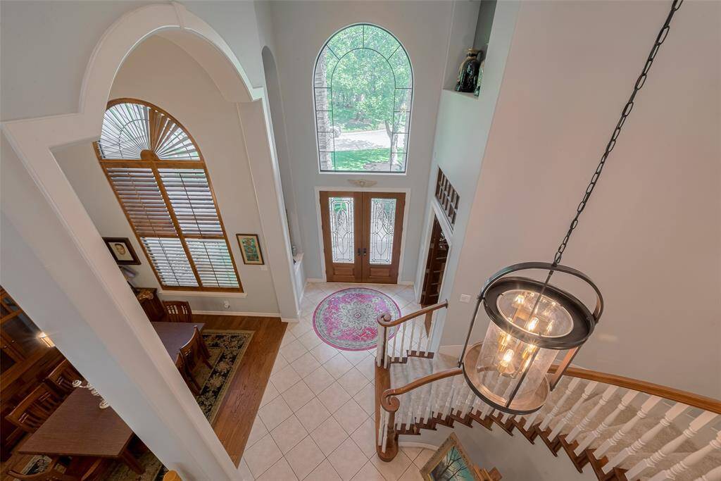 As you head upstairs, you're greeted with a striking view of the home's soaring ceilings and an open overlook to the grand foyer below, enhancing the sense of space and elegance.