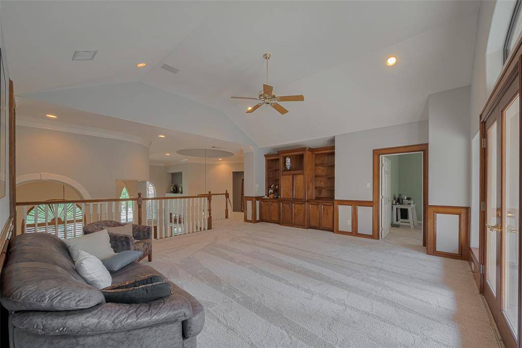 Upstairs, the open game room features high ceilings, rich stained trim, custom built-in cabinets, and more—perfect for relaxing or entertaining.