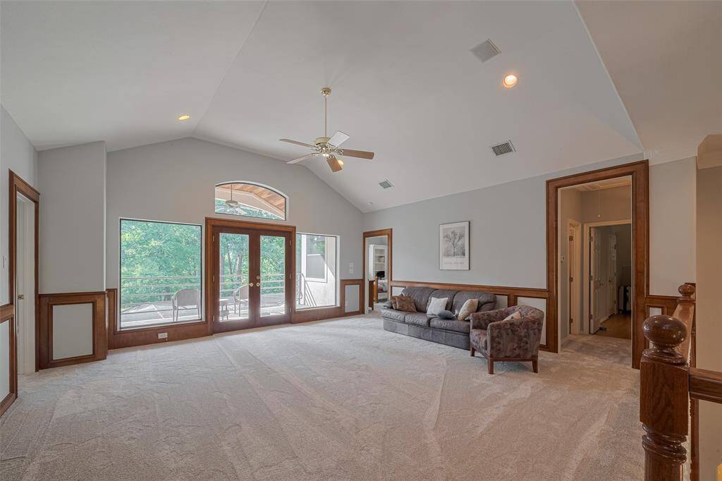 Here’s another view of the game room, highlighting the double glass French doors that open to a covered private balcony with beautiful views of the backyard and pool.