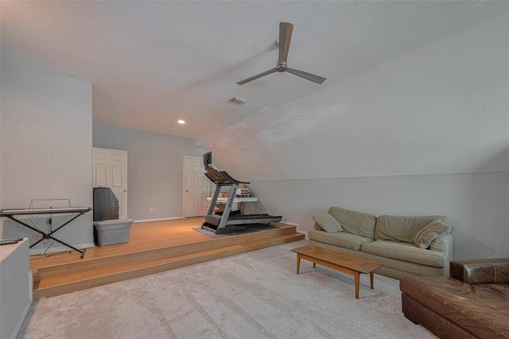 Upon entering the room, you step onto the "stage" area with vinyl flooring, then down into the main section of the media room or fifth bedroom, which features carpets updated in April 2025.