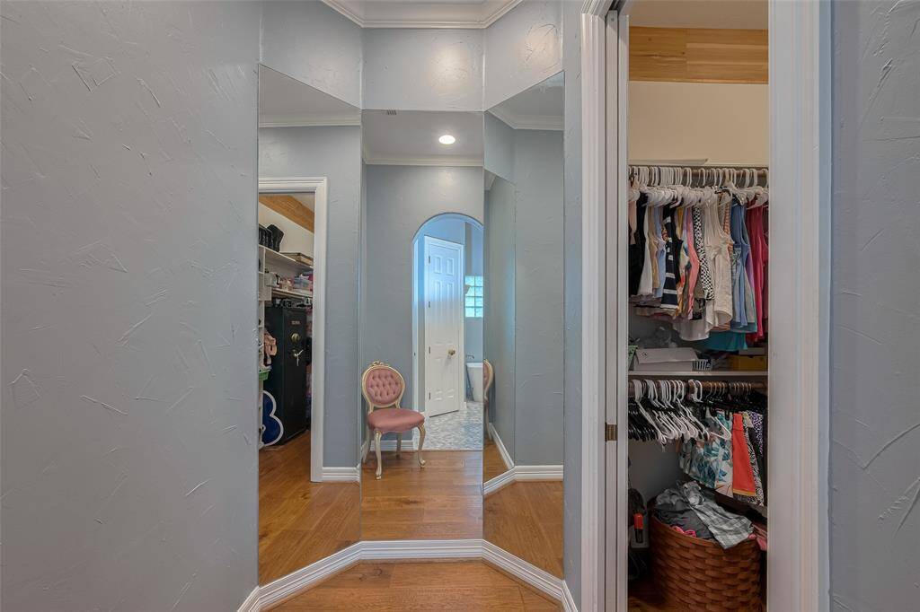 The first of two spacious walk-in closets is conveniently located off the primary bathroom—and just outside one closet, a stylish dressing mirror adds a fun and functional touch.