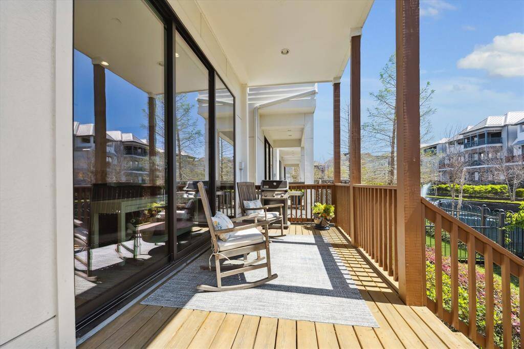 The spacious living area features high ceilings, a cozy fireplace, and stylish decor. It seamlessly connects to the dining area and kitchen, with an elegant staircase leading upstairs. Natural light enhances the bright, modern ambiance.