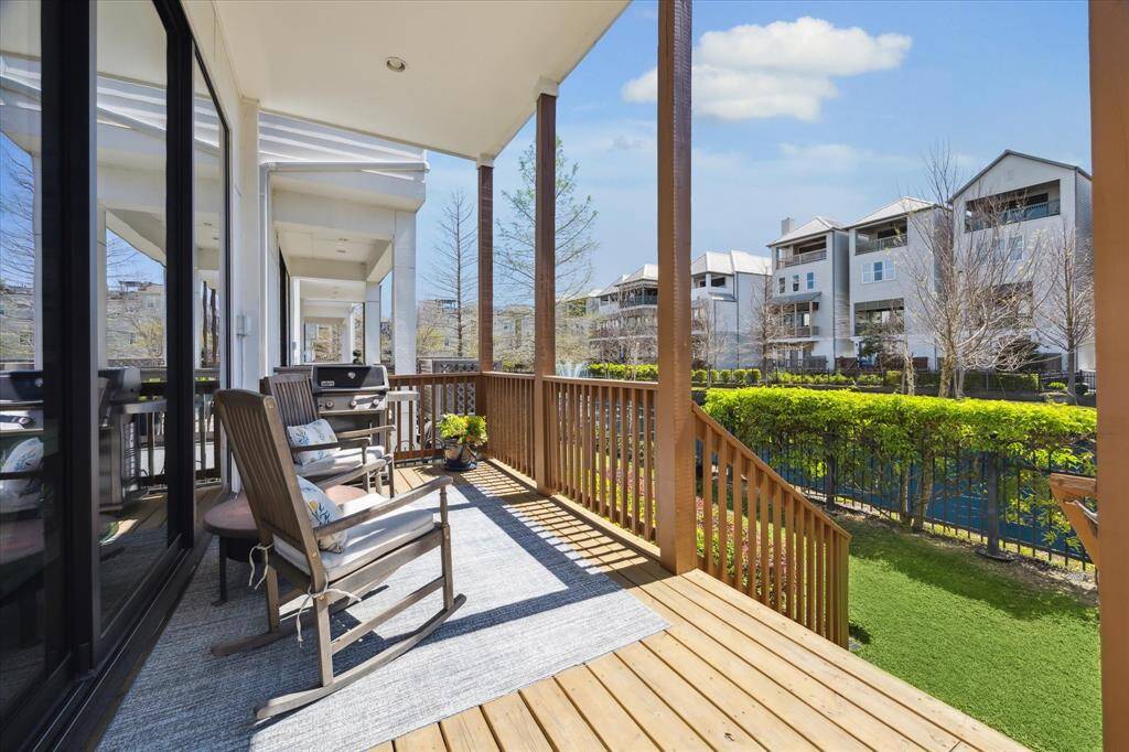 The sunlit rear porch with wooden decking adn room for a grill overlooks the pond. Each level has its own outdoor living area on the water, ideal for relaxation and entertaining.