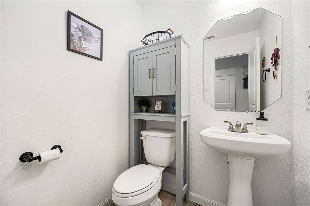 This charming half bath boasts a clean, modern design with a pedestal sink, updated fixtures, and a neutral color palette. Perfect for guests!