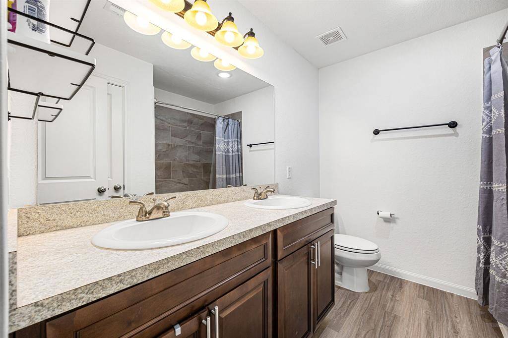 This primary bathroom is definitely move-in ready! Featuring a tub/shower with custom slate tile surround, dark stained cabinets with light countertops, spacious closet, high ceilings, neutral paint, sleek and modern finishes.