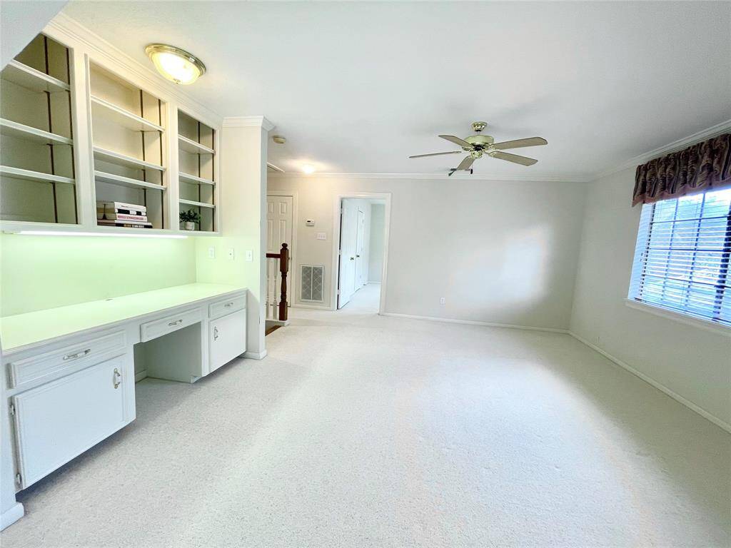 This room room makes a perfect lounge area, game room, or play area. Has lots of natural light, berber carpet, and built-in desk area with shelving and cabinets.