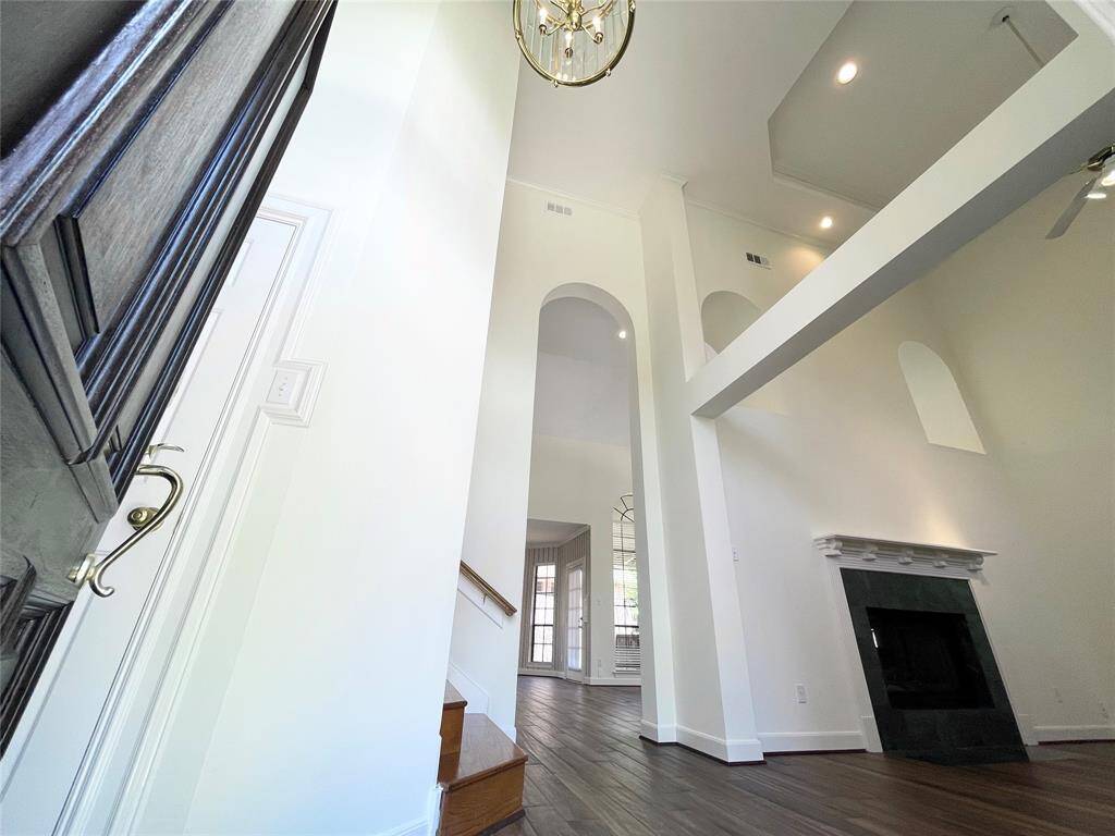 Entrance that has the wow factor with soaring 2-story ceilings, beams, crown molding and archways.